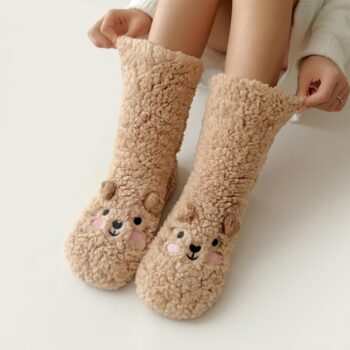 Femme portant des chaussons chaussette pour femme marrons avec une petite tête de chien sur le dessus du pied, sur fond blanc