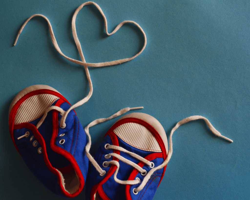 Chaussons pour enfant style petites baskets dont le lacet fait la forme d'un coeur
