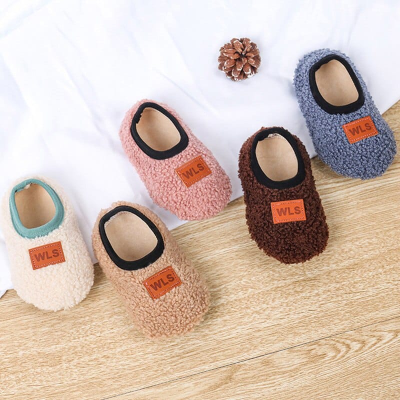 Chaussons chaussettes pour enfant, dont un des deux de chaque paire est disposé , il y a plusieurs couleurs présentées, blanc, beige, rose, marron et bleu