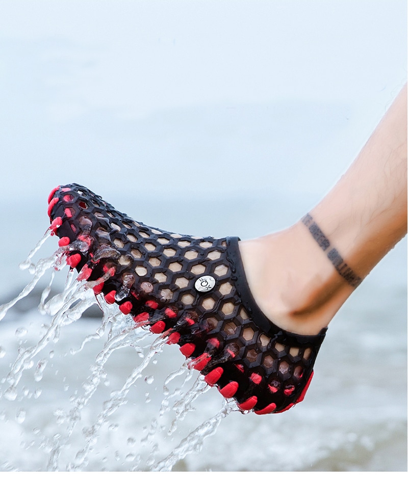 chausson d'eau que l'on voit porté sur un pied, rouge et noir, à trou et qui vient de sortir de l'eau,