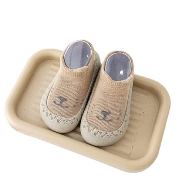 Chaussettes chaussons à semelle en caoutchouc souple pour bébé garçon et fille présentées sur un plateau
