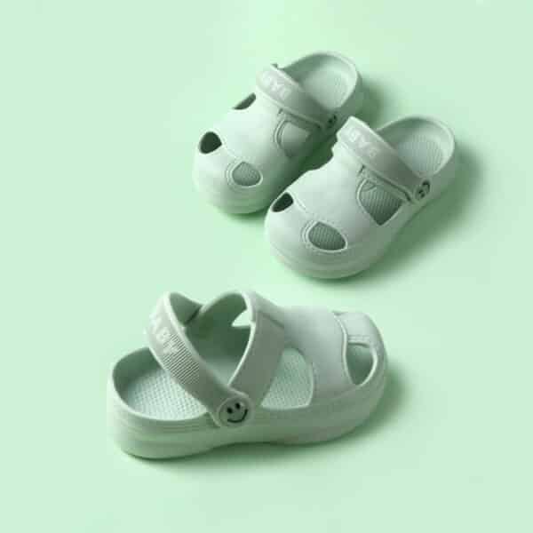 Sandale d'été pour bébé antidérapante et confortable vertes présentées sur fond verre