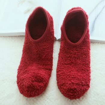 Chaussettes Chausson Fille Style Peluche et Élastique posée sur un tapis et un livre blanc